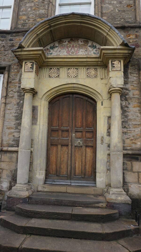 Ornate wooden door of Lancaster’s Judges’ Lodgings, a Grade I listed Georgian townhouse with lion-head carvings and a segmental pediment