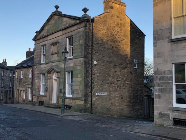 Historic stone dispensary building on Castle Grove in Lancaster with Georgian architecture and cobbled street - the second stop on the Lancaster walks itinerary